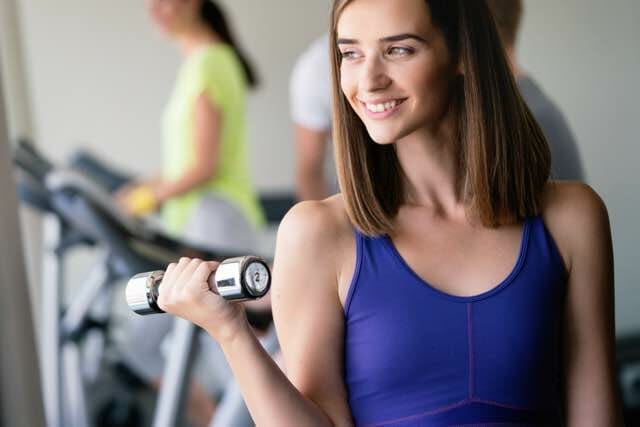 Happy fit fitness girl exercising indoor in fitness center.